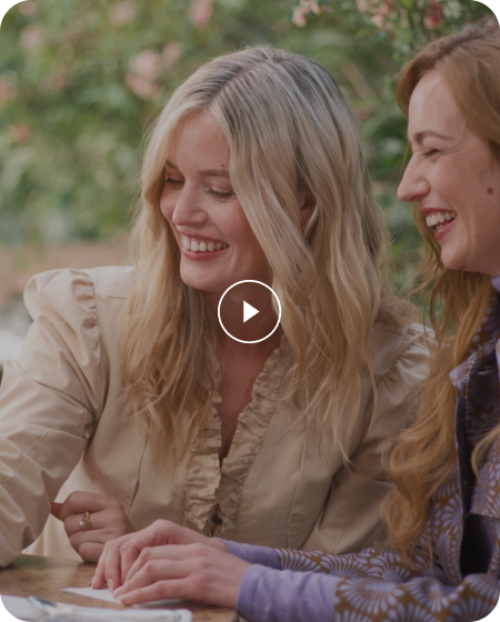 A clapperboard reveals Tom Hardy sat on a dark chair, against a light backdrop. He is wearing a grey jumper and glasses.
